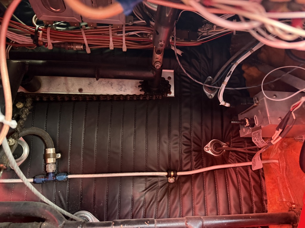 Routing hydraulic lines clear of wiring harnesses under the panel